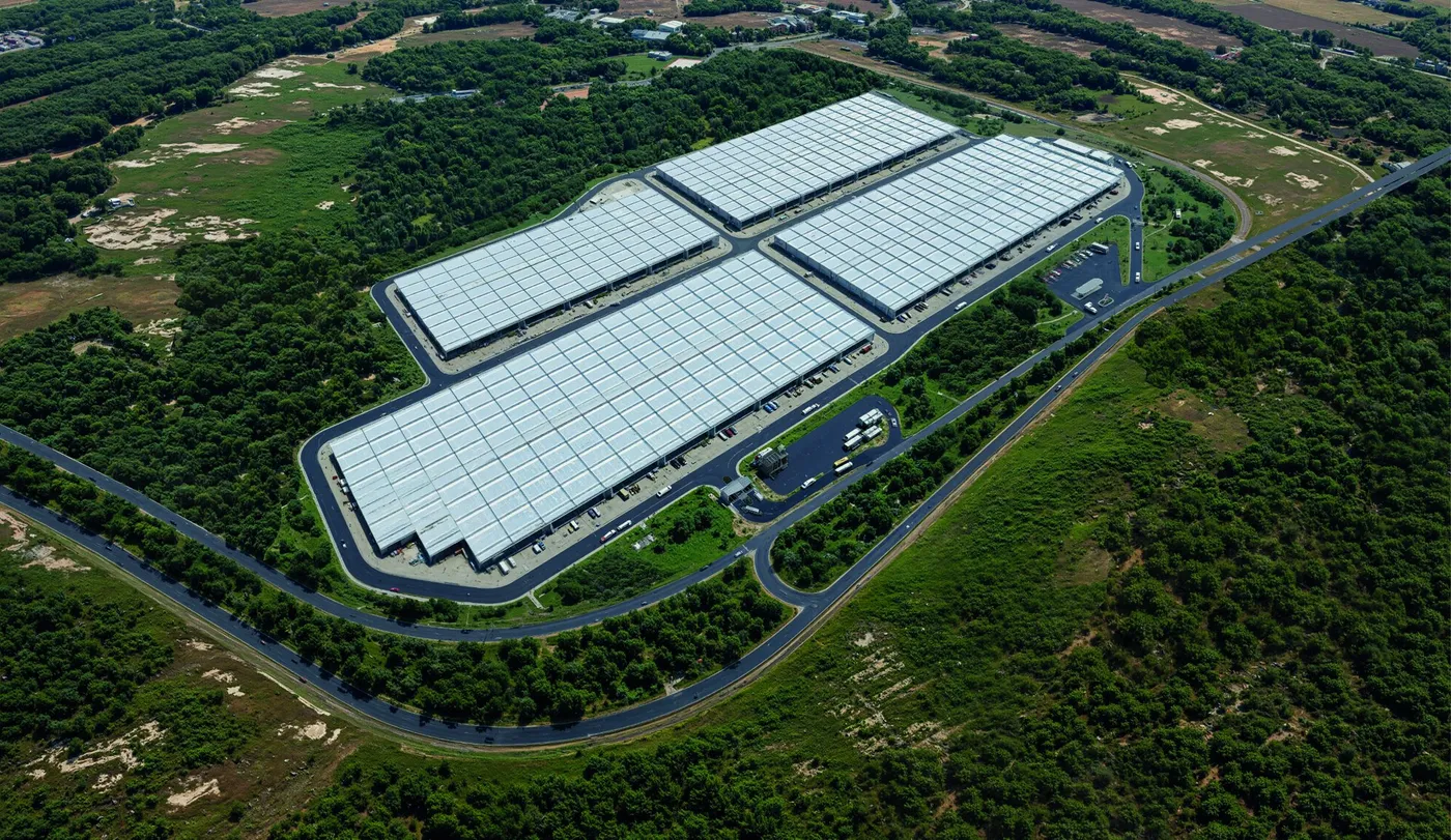 Render del CLIC visto desde arriba: cuatro bloques de bodegas y la v&iacute;a perimetral